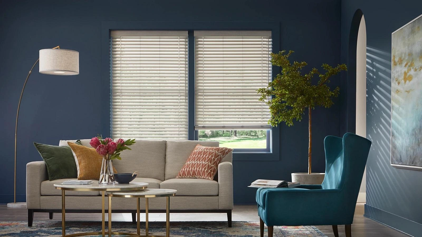 Light Alta faux-wood blinds against a blue living-room wall.