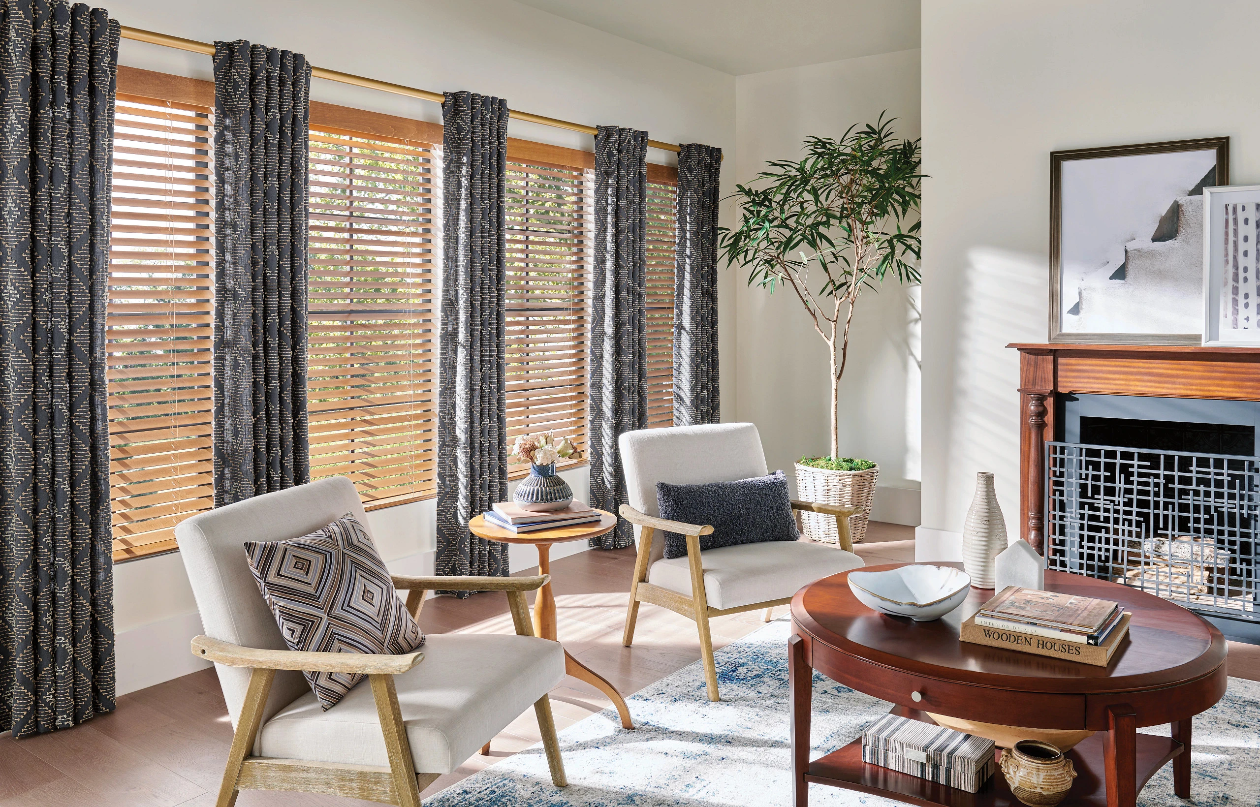 Graber drapery layered with wood blinds and coordinating wood top finishes in a living room.