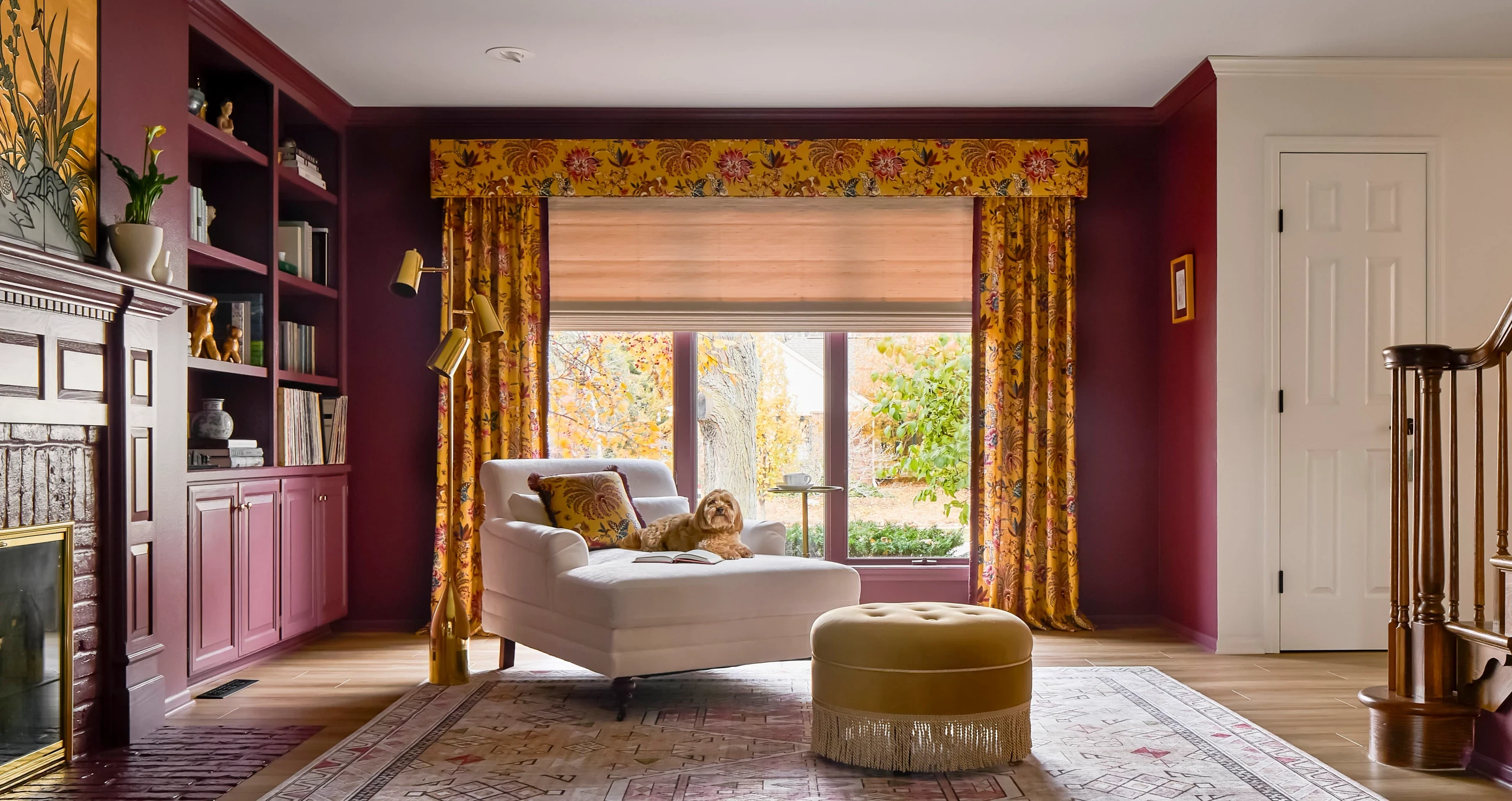 Graber patterned drapery and coordinating fabric valance with a Roman shade in a burgundy room.